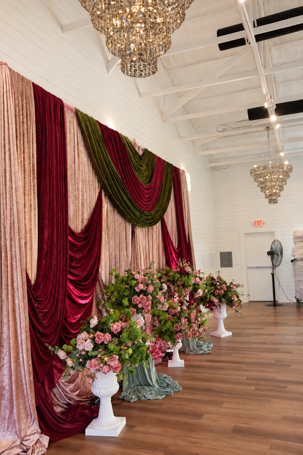 Side view of the ballroom with ceiling drapery and chandeliers