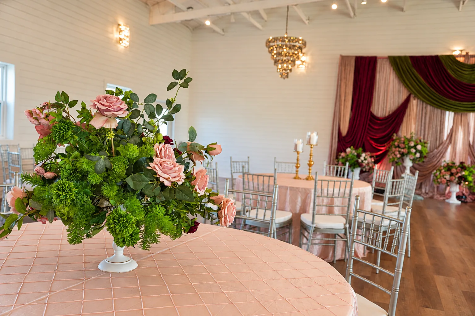 Floral centerpiece and guest table with the event stage in the background