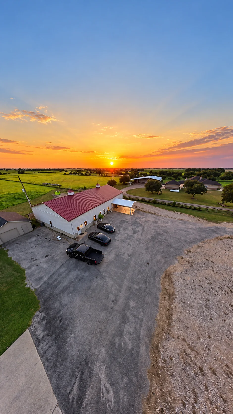 Drone view over the red roof and grounds of Texas AZ Paradise Ranch in Richmond, Texas.