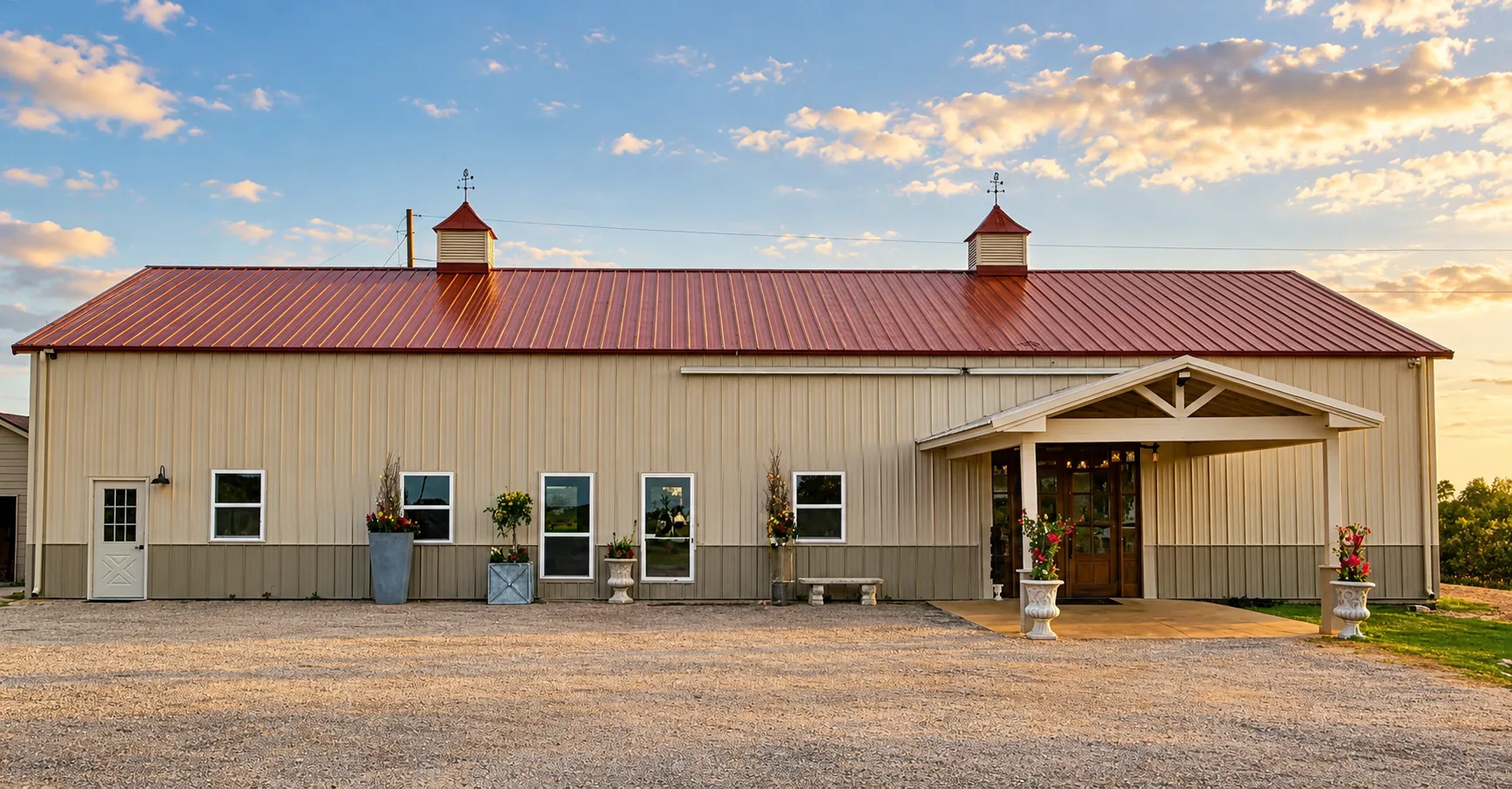 The red-roofed ranch hall and covered entrance in warm afternoon light
