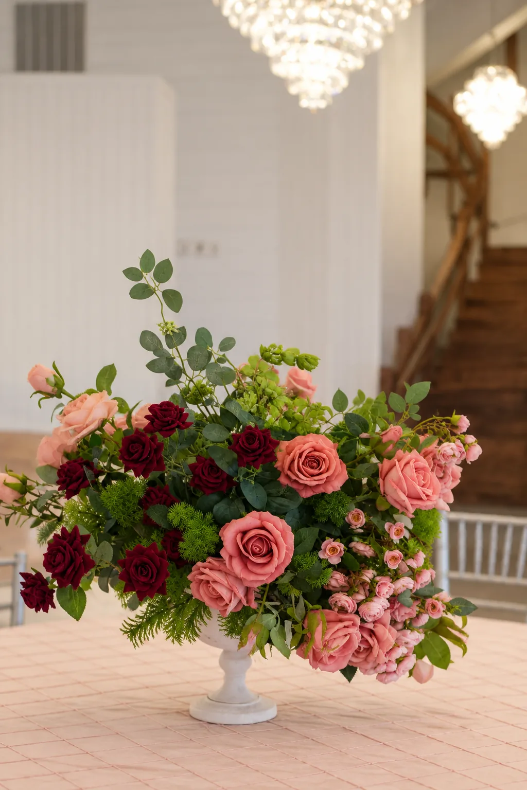 Pink and burgundy rose arrangement with crystal chandeliers inside Texas AZ Paradise Ranch in Richmond, Texas.
